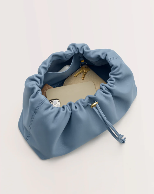 Unterarm‑Schultertasche aus weichem hellblauem Leder mit Schnürzug und geraffter Optik